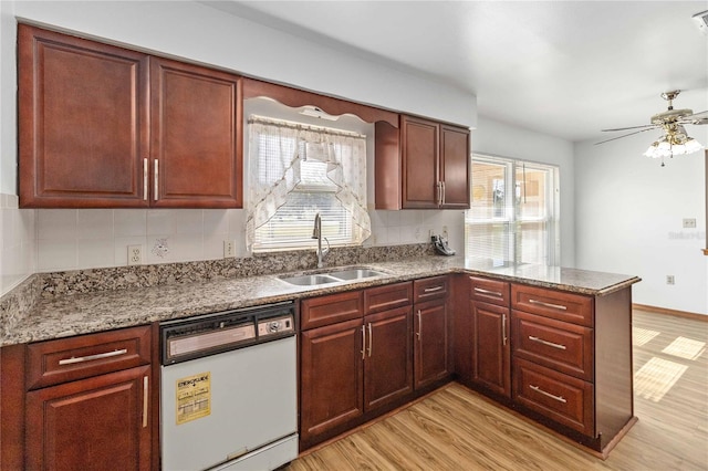 kitchen featuring dishwasher, decorative backsplash, sink, light wood-type flooring, and kitchen peninsula