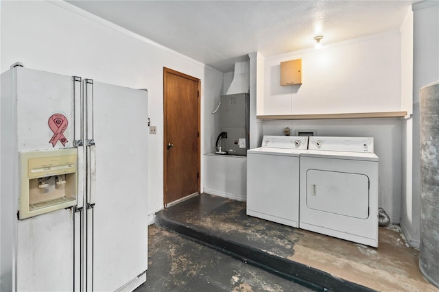 laundry room with heating unit and washer and dryer