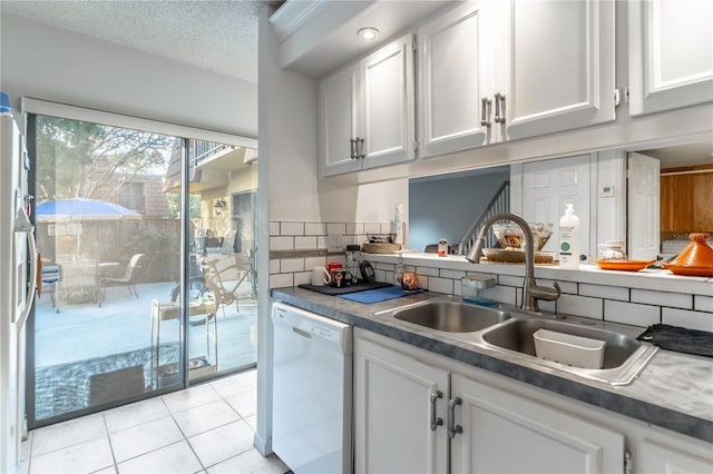 kitchen featuring dishwasher, sink, white cabinets, and a textured ceiling