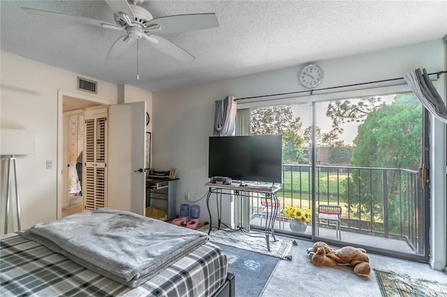 bedroom featuring ceiling fan, access to outside, and a textured ceiling