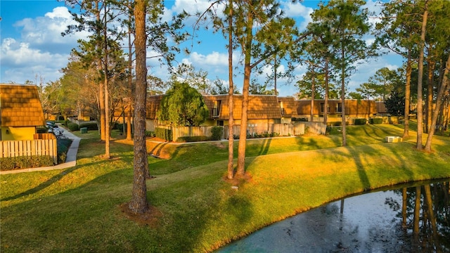 surrounding community featuring a water view and a lawn