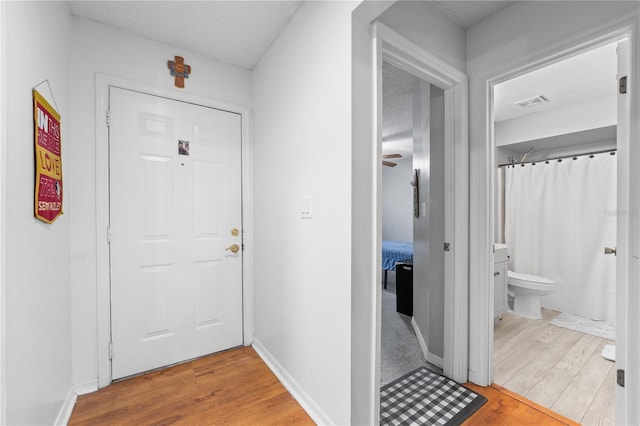 doorway to outside featuring hardwood / wood-style flooring and a textured ceiling