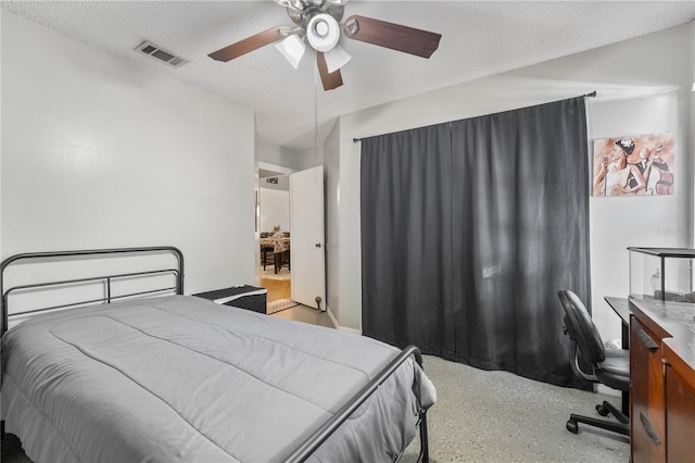 bedroom with ceiling fan and a textured ceiling