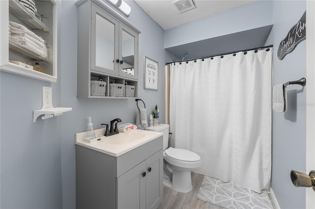 bathroom with vanity, toilet, hardwood / wood-style floors, and curtained shower