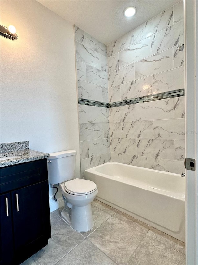 full bathroom with tiled shower / bath, vanity, a textured ceiling, and toilet