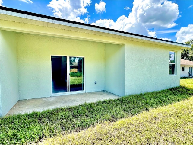 rear view of house featuring a lawn and a patio area