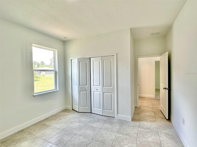 unfurnished bedroom featuring light tile patterned floors and a closet