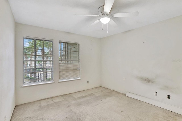 empty room with a ceiling fan and light colored carpet