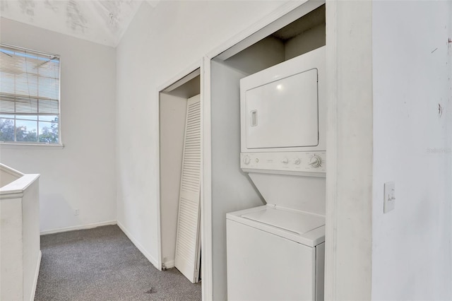 washroom featuring laundry area, carpet, baseboards, and stacked washer / drying machine