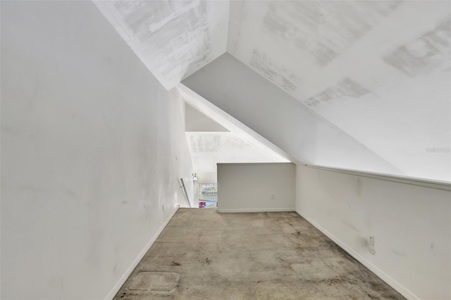 bonus room with light carpet, baseboards, and vaulted ceiling