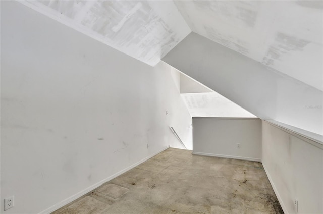 additional living space featuring vaulted ceiling and baseboards