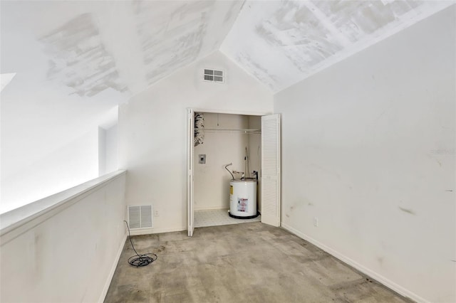 interior space with baseboards, water heater, visible vents, and vaulted ceiling