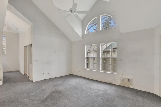 unfurnished living room featuring carpet, ceiling fan, and high vaulted ceiling