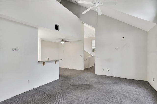 interior space with dark colored carpet, visible vents, vaulted ceiling, and ceiling fan