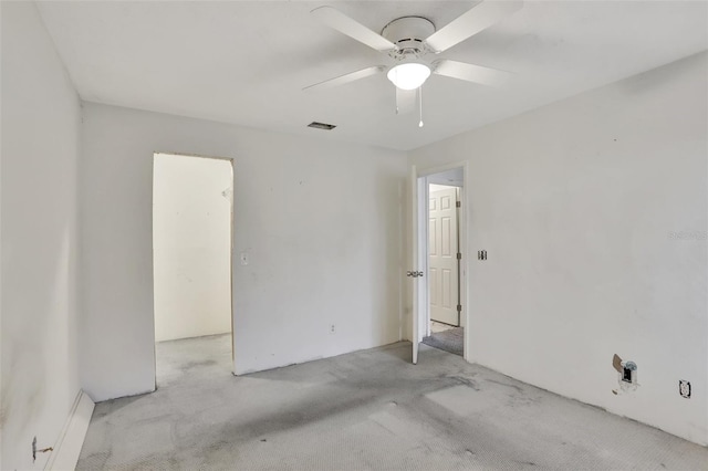 unfurnished room with a ceiling fan, light colored carpet, and visible vents