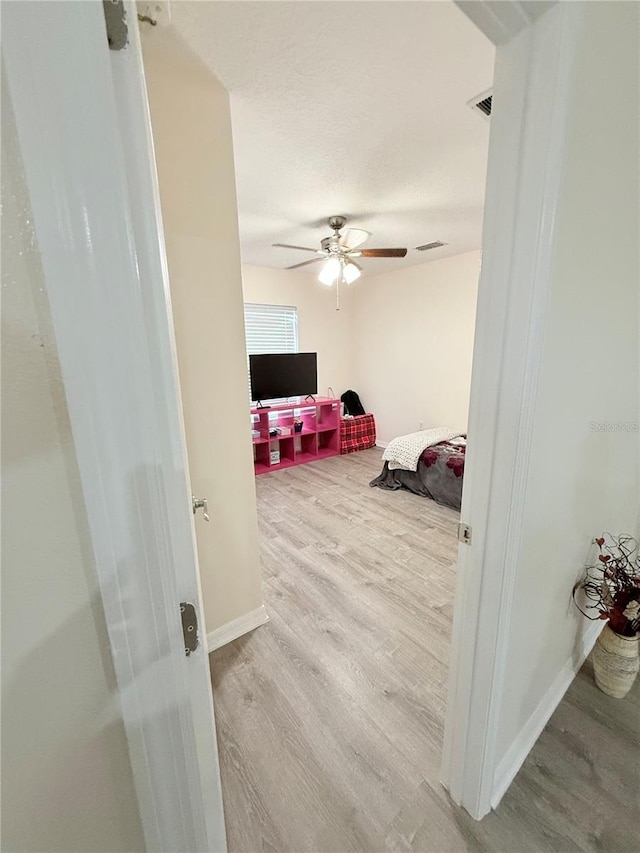 bedroom with light hardwood / wood-style floors and ceiling fan