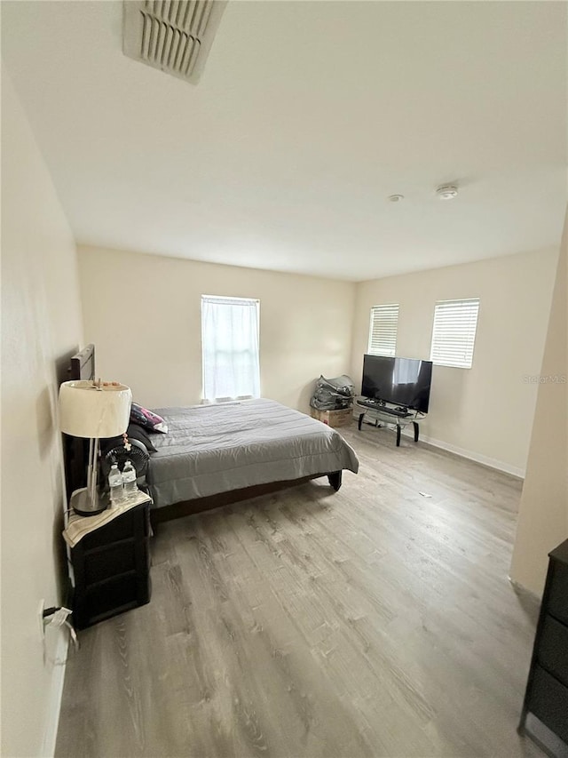 bedroom featuring light hardwood / wood-style flooring and multiple windows