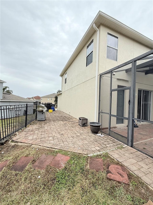 exterior space featuring glass enclosure and a patio