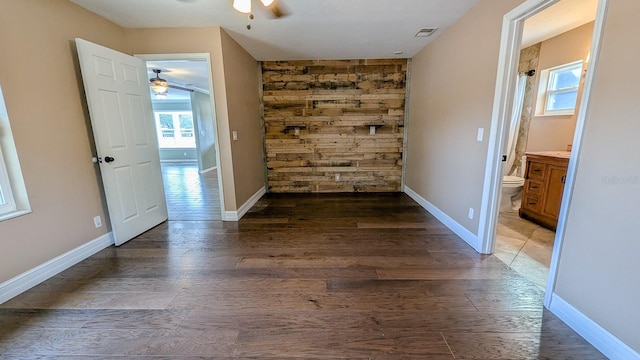 empty room with ceiling fan and dark hardwood / wood-style floors