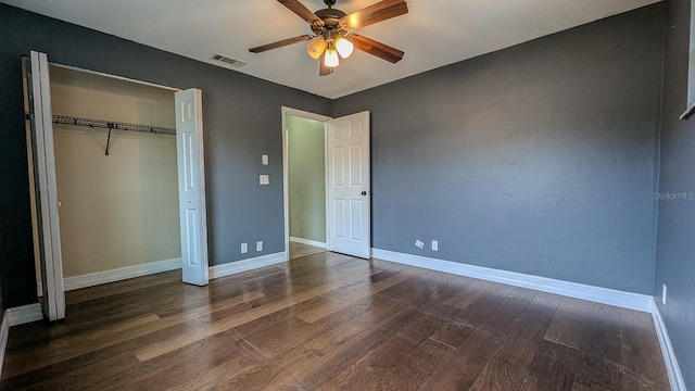 unfurnished bedroom with a closet, dark hardwood / wood-style floors, and ceiling fan