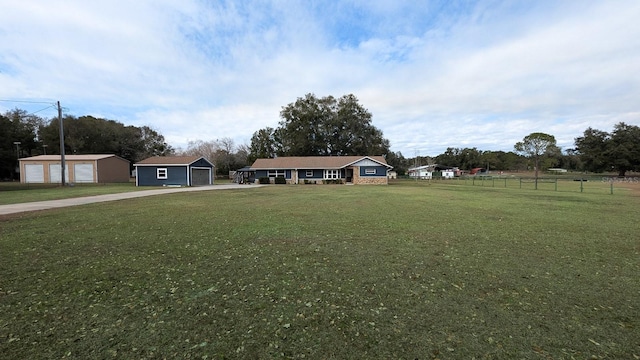 single story home featuring a front yard, an outdoor structure, and a garage