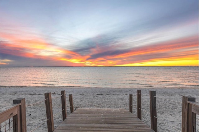 dock area with a water view and a view of the beach