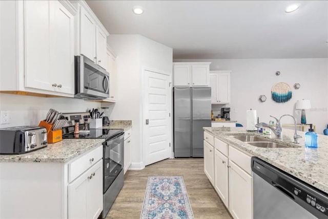 kitchen with sink, white cabinetry, and stainless steel appliances