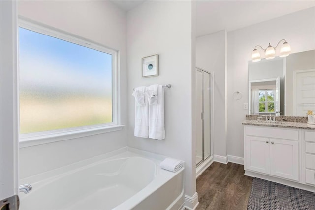 bathroom with independent shower and bath, hardwood / wood-style flooring, and vanity