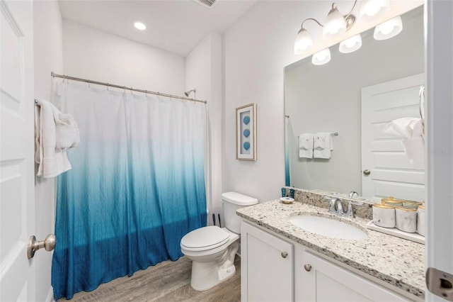 full bathroom featuring hardwood / wood-style flooring, toilet, shower / bath combination with curtain, and vanity