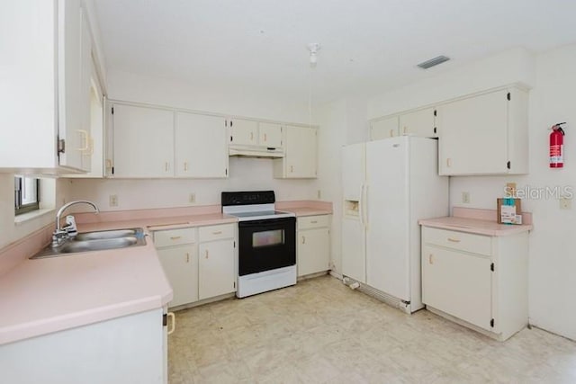 kitchen with light countertops, white appliances, light floors, and white cabinetry