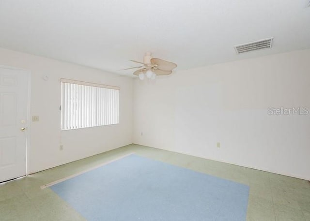 unfurnished room featuring a ceiling fan, visible vents, and tile patterned floors