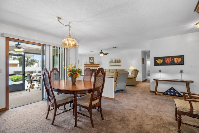 carpeted dining area with ceiling fan with notable chandelier and a textured ceiling