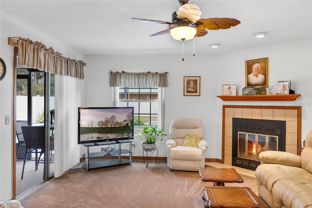 carpeted living room featuring ceiling fan and a tile fireplace