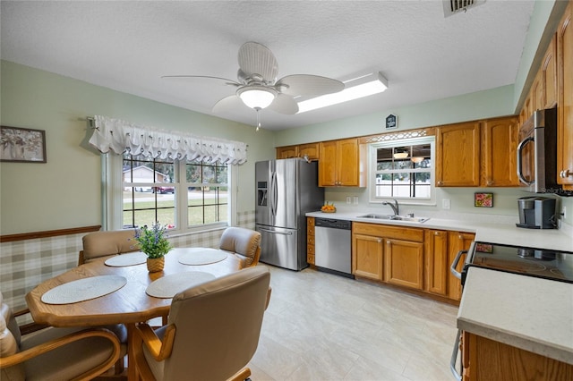 kitchen featuring sink, ceiling fan, appliances with stainless steel finishes, and a textured ceiling