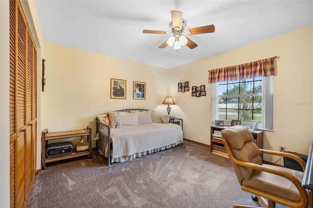 carpeted bedroom featuring ceiling fan and a closet