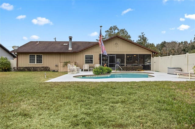 back of house with a fenced in pool, a patio area, a yard, and a sunroom