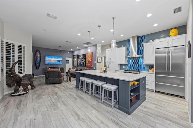 kitchen featuring a kitchen island, white cabinetry, and built in fridge