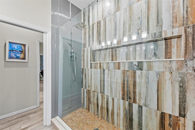 bathroom with hardwood / wood-style flooring and tiled shower