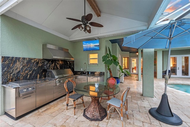 exterior space featuring exhaust hood, vaulted ceiling with beams, backsplash, gray cabinets, and ceiling fan