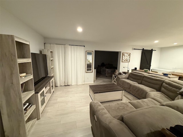 living room with a barn door and light hardwood / wood-style flooring