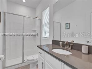 bathroom featuring radiator heating unit, a shower with door, toilet, and vanity