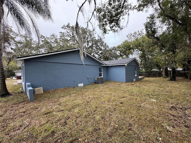 view of property exterior featuring central AC and a lawn