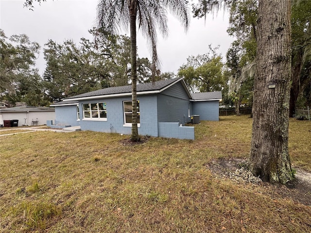 exterior space featuring a front lawn and central air condition unit