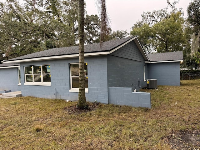 view of property exterior featuring central AC and a lawn