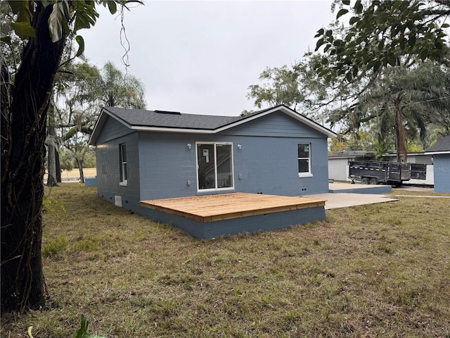 back of property featuring a yard, a deck, and a patio area