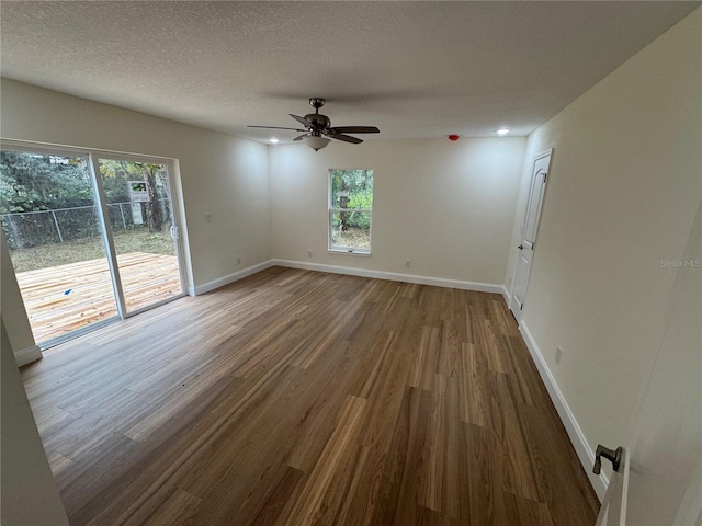 unfurnished room featuring hardwood / wood-style flooring, ceiling fan, and a textured ceiling