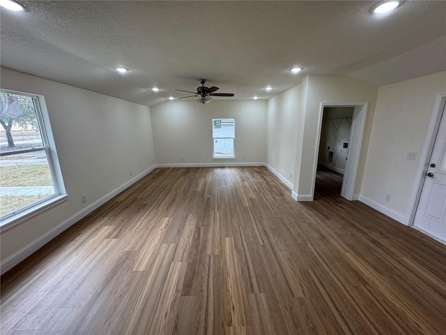 unfurnished room featuring ceiling fan, wood-type flooring, a textured ceiling, and lofted ceiling