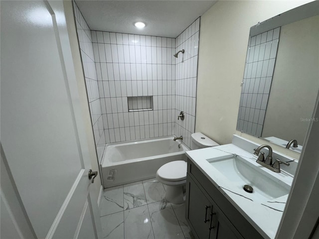 full bathroom featuring tiled shower / bath, vanity, and toilet