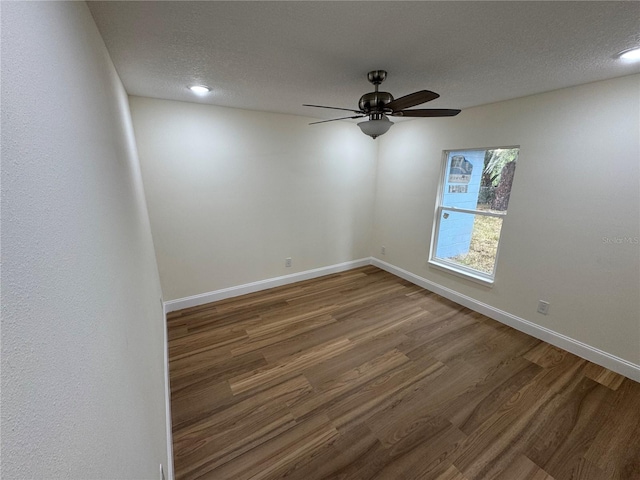 spare room with ceiling fan, dark wood-type flooring, and a textured ceiling