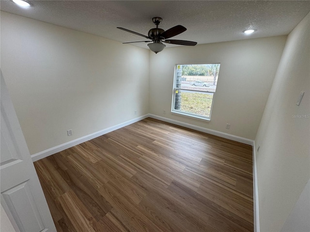 empty room featuring ceiling fan, hardwood / wood-style floors, and a textured ceiling